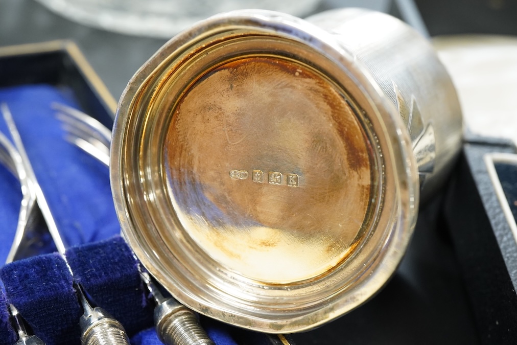 A silver christening mug, Birmingham, together with three cased sets, silver rimmed cut glass bowl, plated cocktail shaker etc